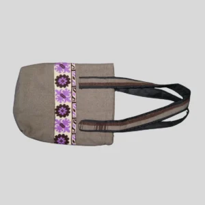 Natural canvas tote bag with purple and black geometric cross-stitch trim panel