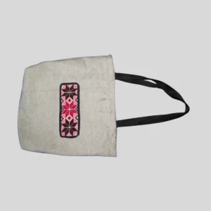 Beige natural canvas tote with pink and black geometric cross-stitch trim panel